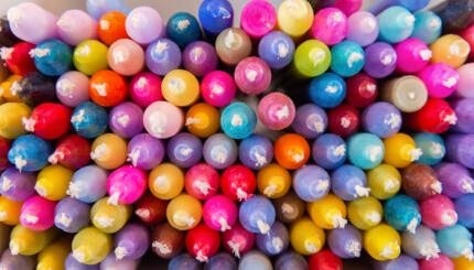 photograph of a bin of colorful candles